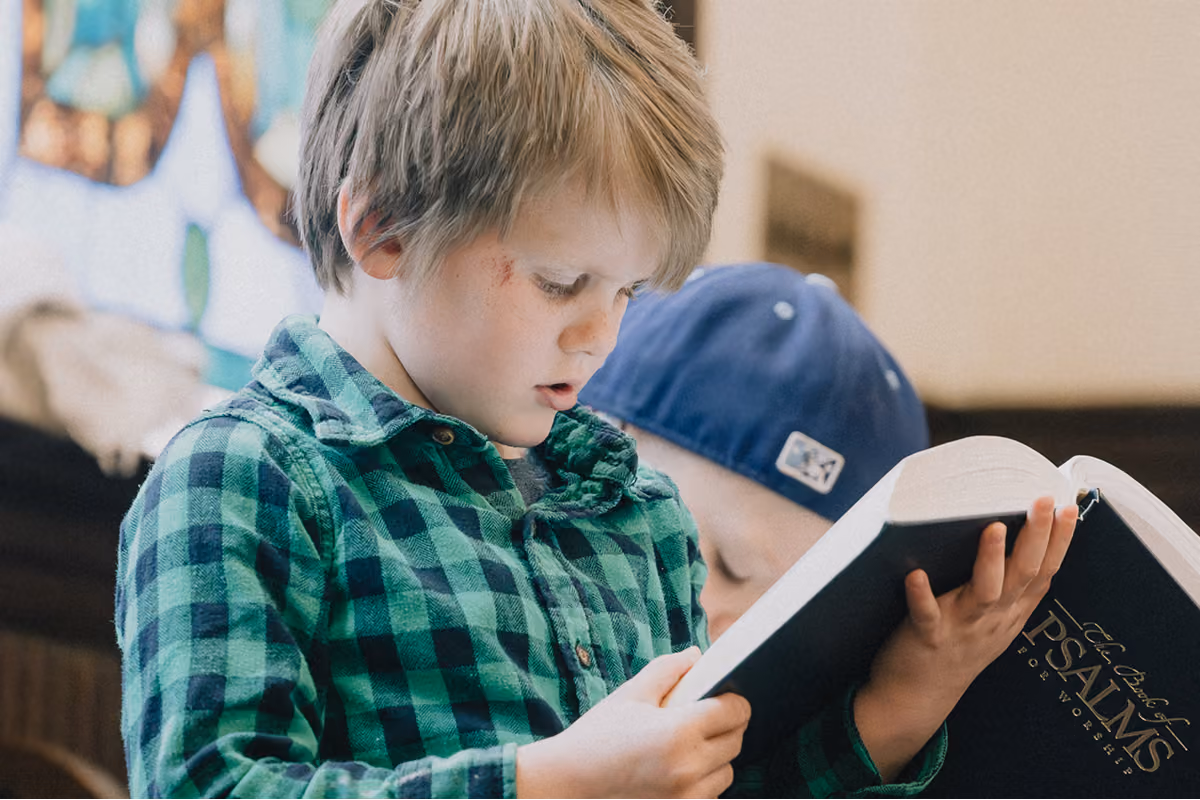 A boy reading the Bible before worship