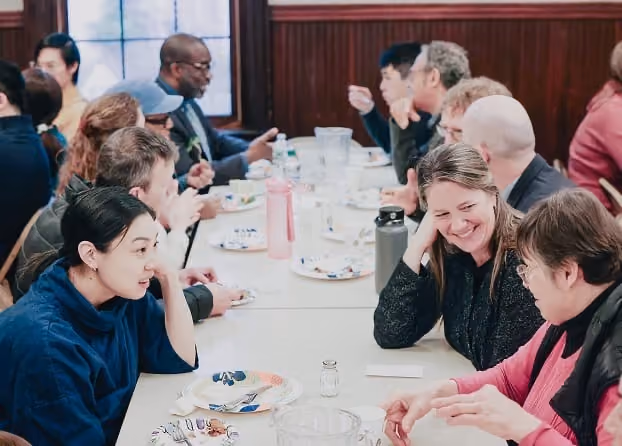 Members sharing a meal and conversation around a table
