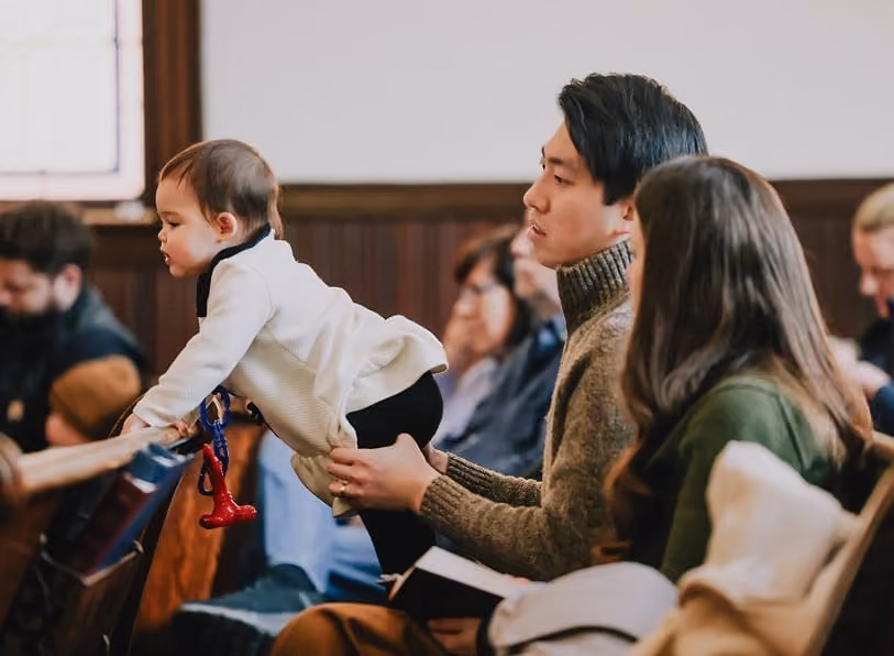 A parent holding a young child during the worship service